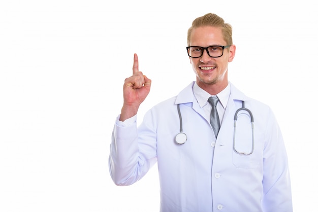 Foto de estúdio do médico jovem feliz sorrindo enquanto aponta a Finlândia