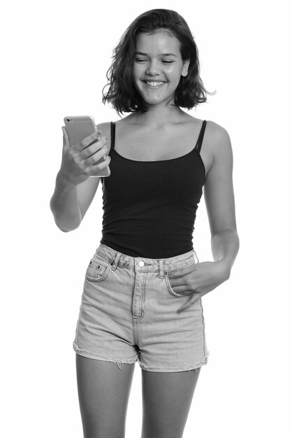 Foto de estúdio em preto e branco de uma jovem adolescente multiétnica bonita com cabelo curto isolado contra um fundo branco