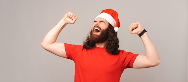 Foto de faixa de um poderoso vencedor barbudo usando um chapéu vermelho de Natal