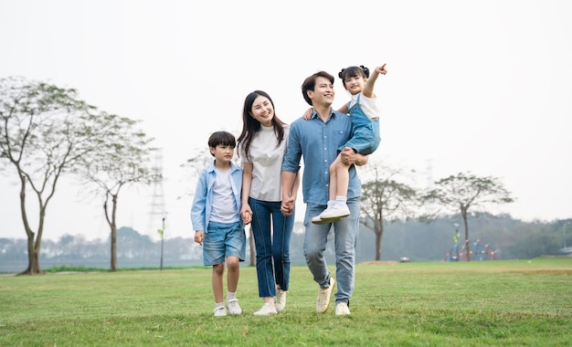 Foto de família asiática caminhando juntos no parque