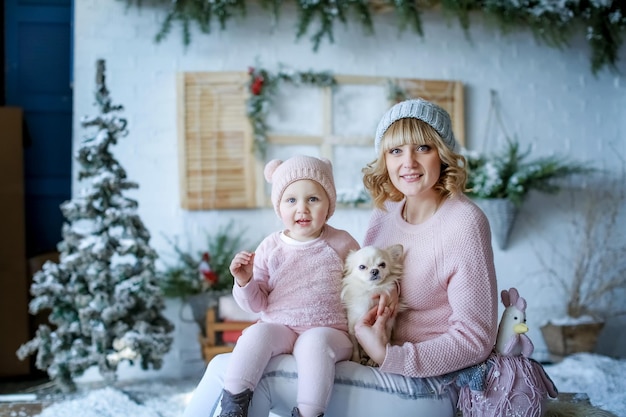 Foto de família de inverno no estúdio com paisagem no fundo de neve artificial.