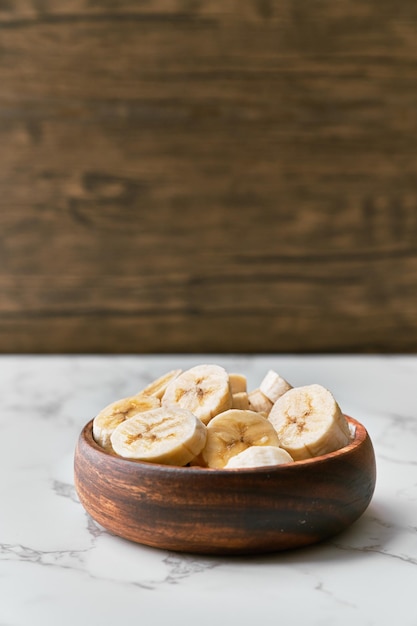 Foto de fatias de banana em uma tigela sobre uma mesa de mármore