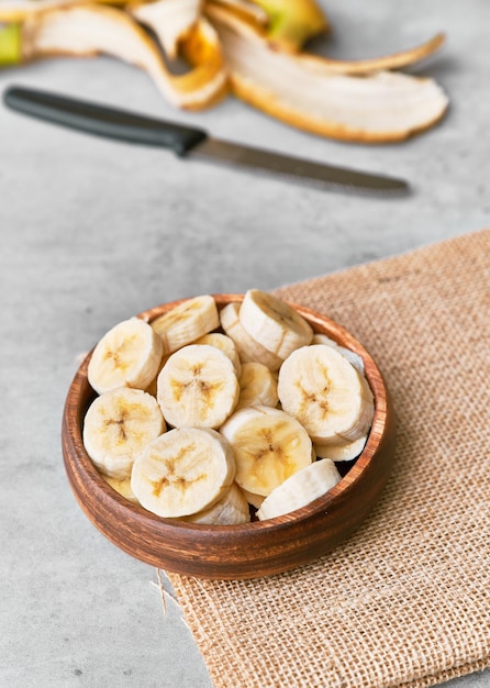 Foto foto de fatias de banana em uma tigela sobre uma superfície de concreto