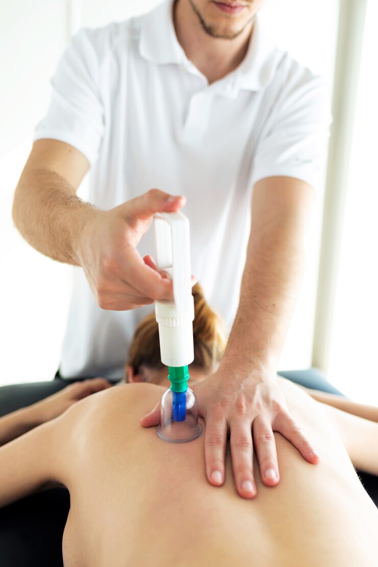 Foto foto de fisioterapeuta aplicando tratamento de ventosa no paciente em uma sala de fisioterapia.