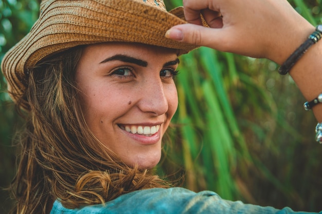 Foto foto de foco raso de uma mulher europeia com um chapéu de cowboy na praia