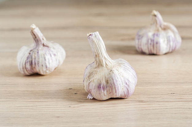 Foto de foco seletivo de cabeças de alho na mesa de madeira