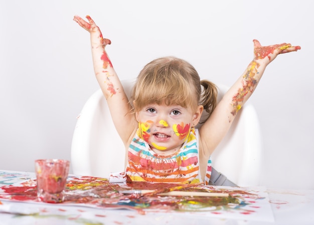 Foto foto de foco seletivo de uma menina pintando e brincando