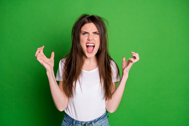 Foto de garota atraente com raiva usando camiseta branca e tem problema com o cabelo dos braços procure um fundo de cor verde isolado