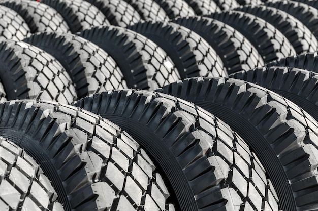 Foto de grandes pneus pretos sobre rodas para carros grandes.