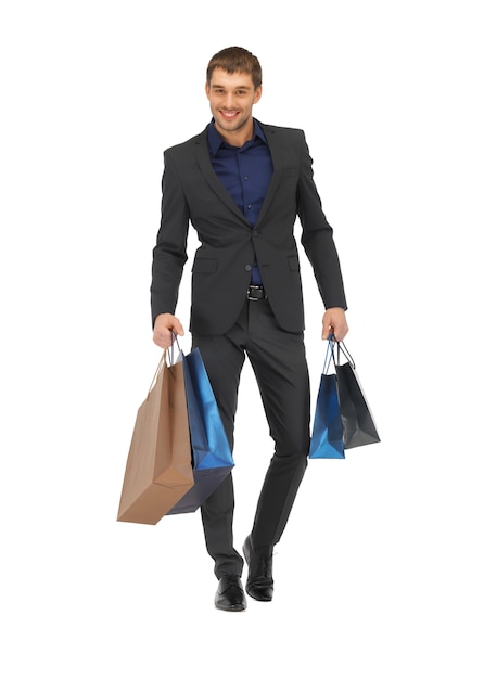 Foto foto de homem bonito de terno com sacolas de compras.