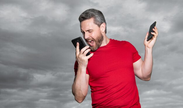 Foto de homem bravo gritando falando ao telefone homem falando ao telefone no fundo do céu