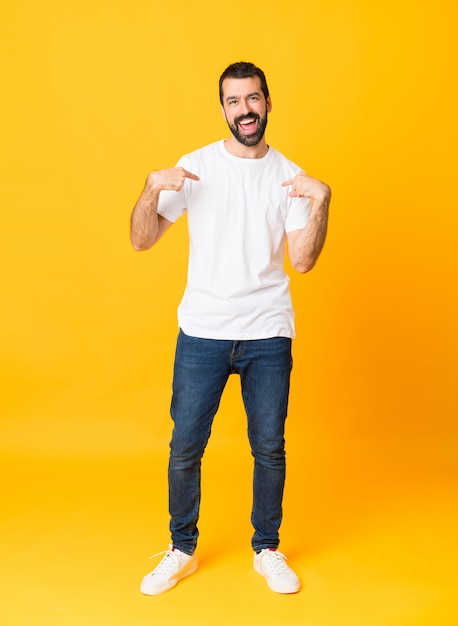 Foto de homem com barba sobre amarelo isolado com expressão facial de surpresa