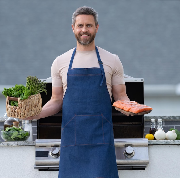 Foto de homem de churrasco feliz com homem de churrasco de peixe salmão com homem de churrasco de salmão