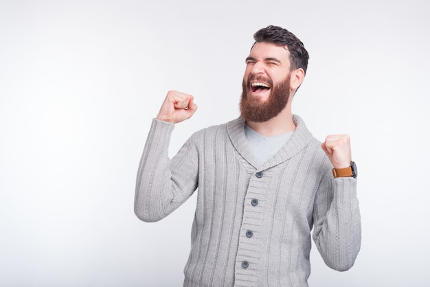 Foto de homem feliz comemorando sucesso em pé sobre fundo branco