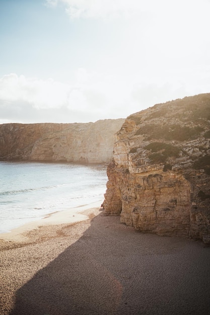 Foto de incríveis falésias ao lado da costa com sol ao fundo no sul de Portugal