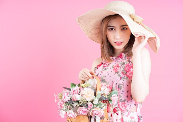 Foto de jovem asiática usando vestido de flores em fundo rosa