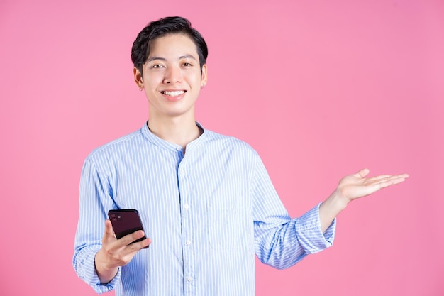 Foto de jovem asiático usando smartphone em segundo plano