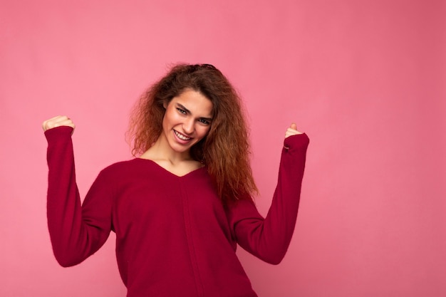 Foto de jovem emocional feliz positiva encantadora morena encaracolada com emoções sinceras vestindo