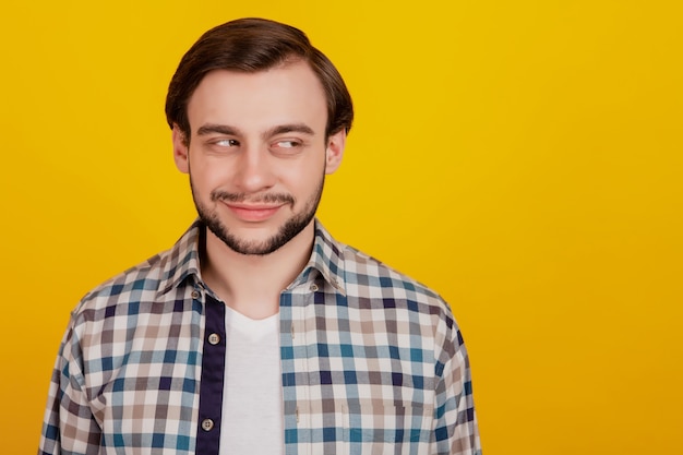 Foto de jovem feliz sorriso positivo olhar espaço vazio curioso interessado isolado em fundo de cor amarela