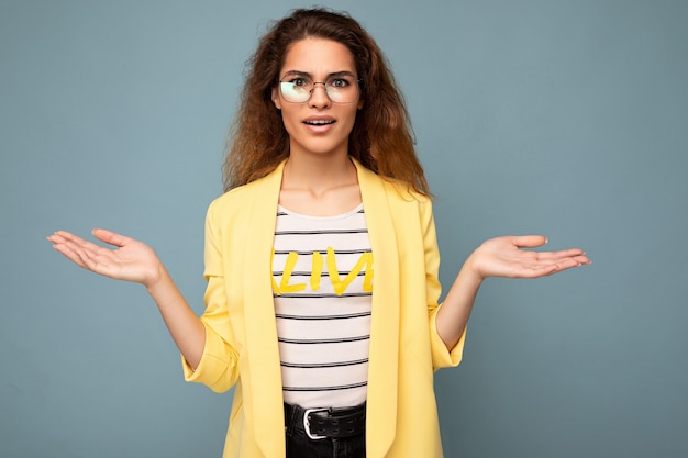 Foto de jovem positiva pensativa linda morena encaracolada com emoções sinceras vestindo