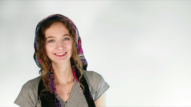 Foto de jovem sorridente em pose de lenço na cabeça