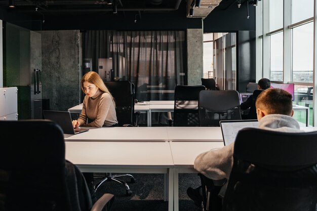 Foto de jovens trabalhando em um computador em um escritório de coworking moderno