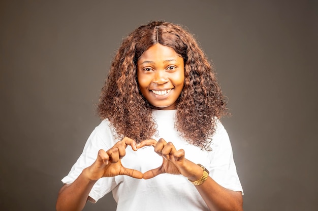 Foto de linda dama negra fazendo figura de coração dedos mãos sorrindo