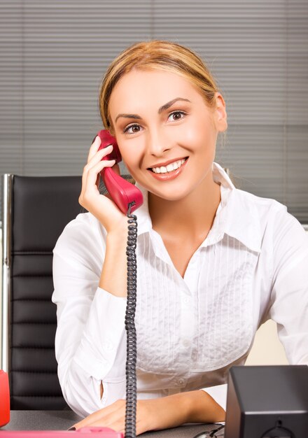 foto de linda garota com telefone no escritório