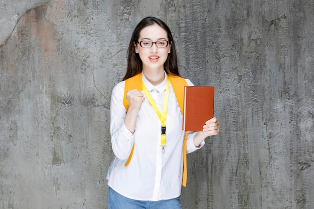 Foto de linda garota de óculos posando com livro. Foto de alta qualidade