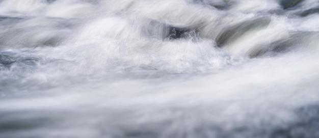 Foto de longa exposição - água fluindo sobre rochas tudo suave, apenas algumas gotas de água em foco.