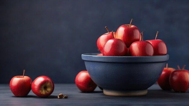 Foto de maçãs vermelhas frescas e prato interior macio em mesa azul escuro