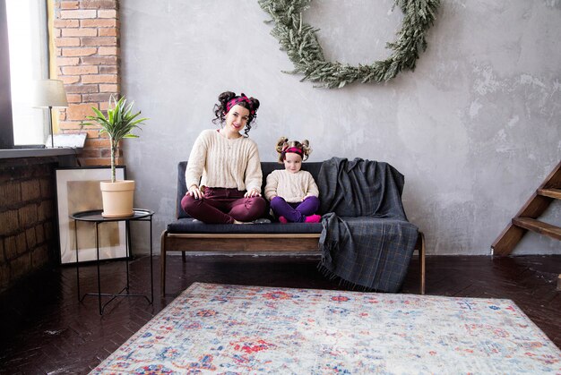 Foto de mãe e filha juntas em casa no sofá