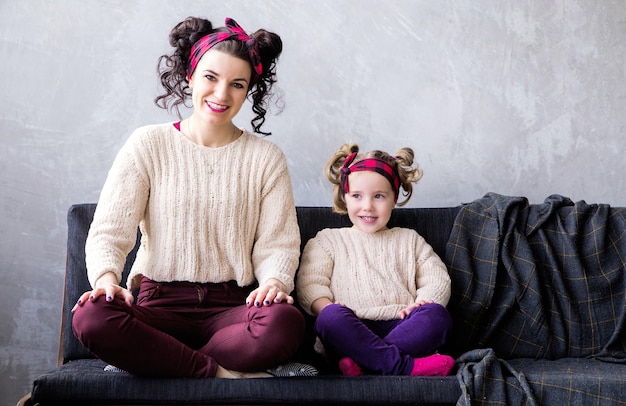 Foto de mãe e filha juntas em casa no sofá