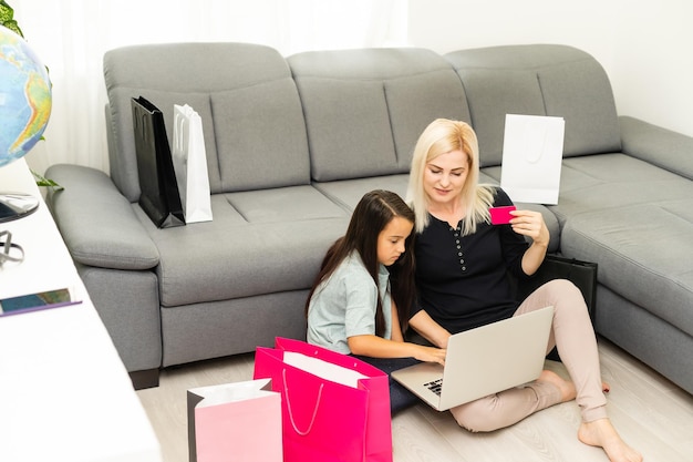 foto de mãe e filho felizes com um laptop, fazendo compras online