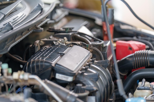 Foto de mecânico de automóveis repara um motor de carro em sua oficina