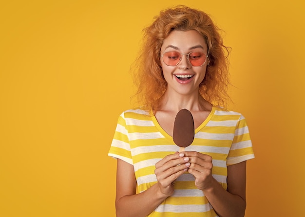 Foto foto de menina com sorvete no espaço de cópia de verão menina com gelado isolado em amarelo