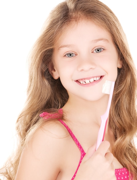 foto de menina feliz com escova de dentes sobre branco