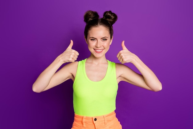 Foto de menina positiva mostra sinal de polegar para cima usar camiseta isolada sobre fundo de cor roxa brilho brilhante