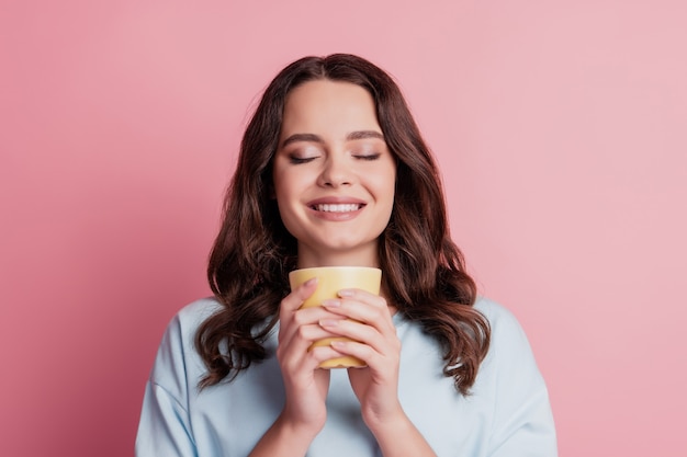 Foto de menina segurar copo bebida cacau relaxar fechar olhos sorriso dentuço