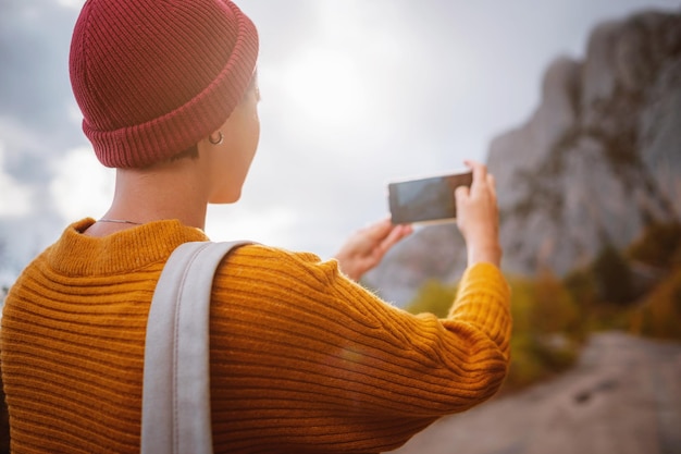 Foto de moda ao ar livre de uma jovem linda cercada pela floresta de outono nas montanhas