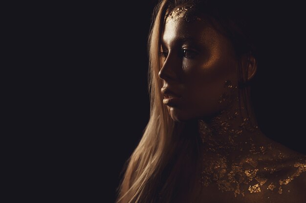 Foto de moda de uma bela jovem. close-up da garota do retrato de ouro de beleza. copyspace.
