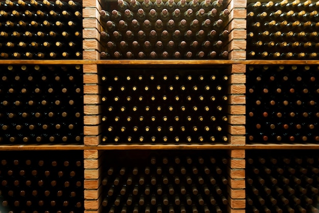 Foto foto de muitas garrafas de vinho incrível em uma vinícola subterrânea