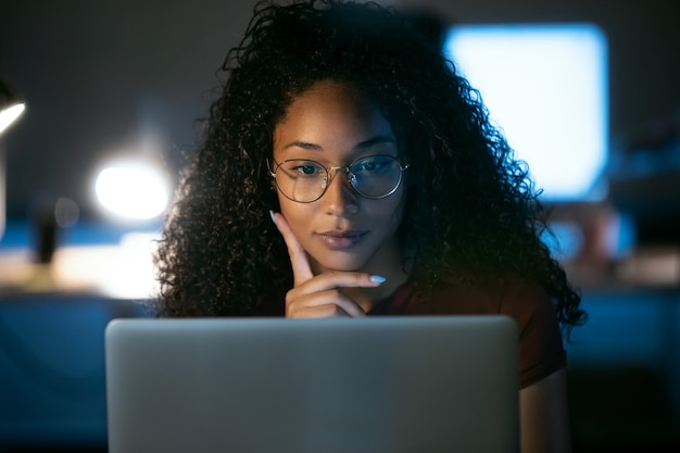 Foto foto de mulher de negócios jovem confiante trabalhando com laptop sentado no escritório.