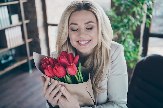 Foto de mulher de negócios, olhos fechados, abraço com flores