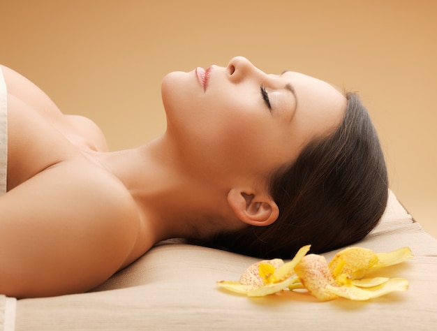 foto de mulher em salão de spa deitada na mesa de massagem