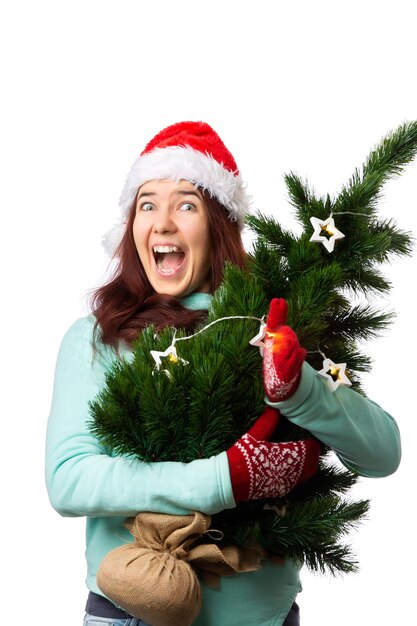 Foto de mulher feliz com chapéu de Papai Noel com árvore de Natal