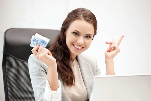 foto de mulher feliz com laptop e dinheiro em euros