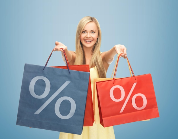 Foto de mulher feliz segurando sacolas de compras com sinal de porcentagem