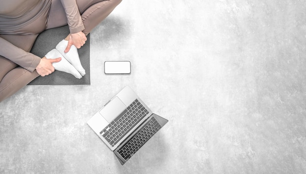 Foto de mulher praticando treinamento de ioga online em casa com o laptop.