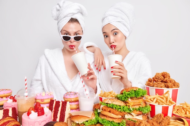 Foto de mulheres melhores amigas bebem refrigerante com quebra de dieta, nutrição não saudável, fast food delicioso